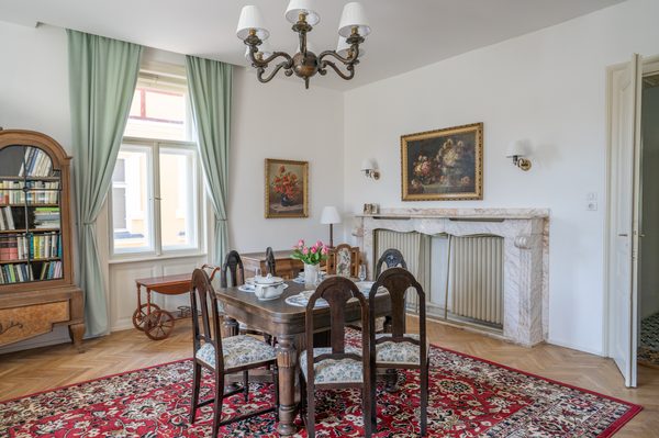 Salon s jídelním stolem, knihovnou a dobovým nábytkem